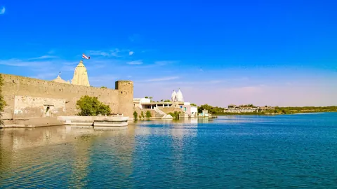 Narayan Sarovar lake with temple walls and shikhara on its bank