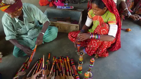 Artisans with brightly striped lacquered wooden spoons and toys
