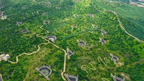 Aerial view of Smritivan on Bhujiyo Hill, with memorial check dams and winding paths among green trees